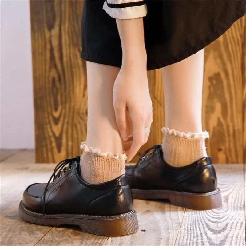Women's black retro Mary Jane pumps with front lace-up and low square heel on a white background.