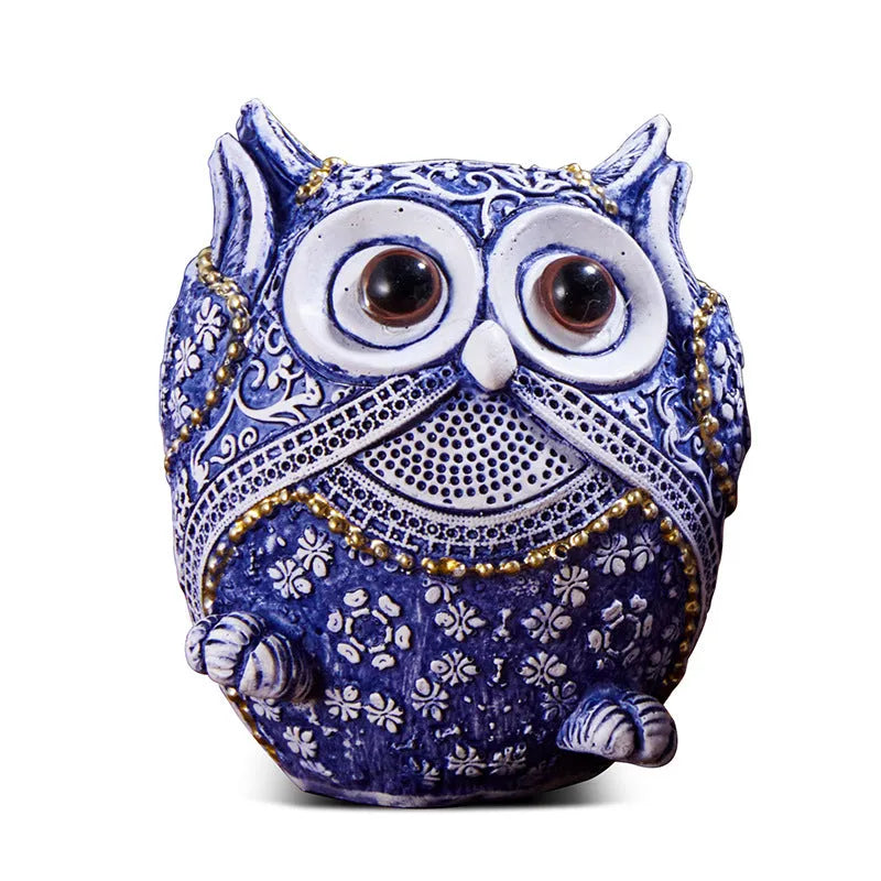 Three blue and white owl resin ornaments in large and small sizes on a white shelf