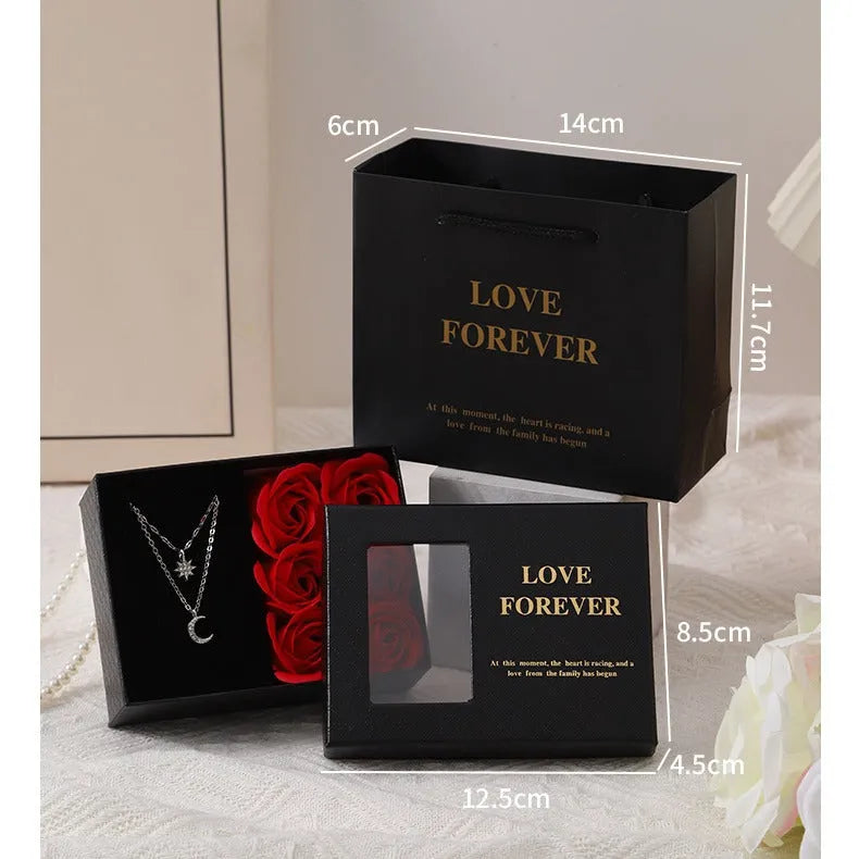 Six red soap flower roses in a black gift box with decorative handbag for Valentine's Day presents.