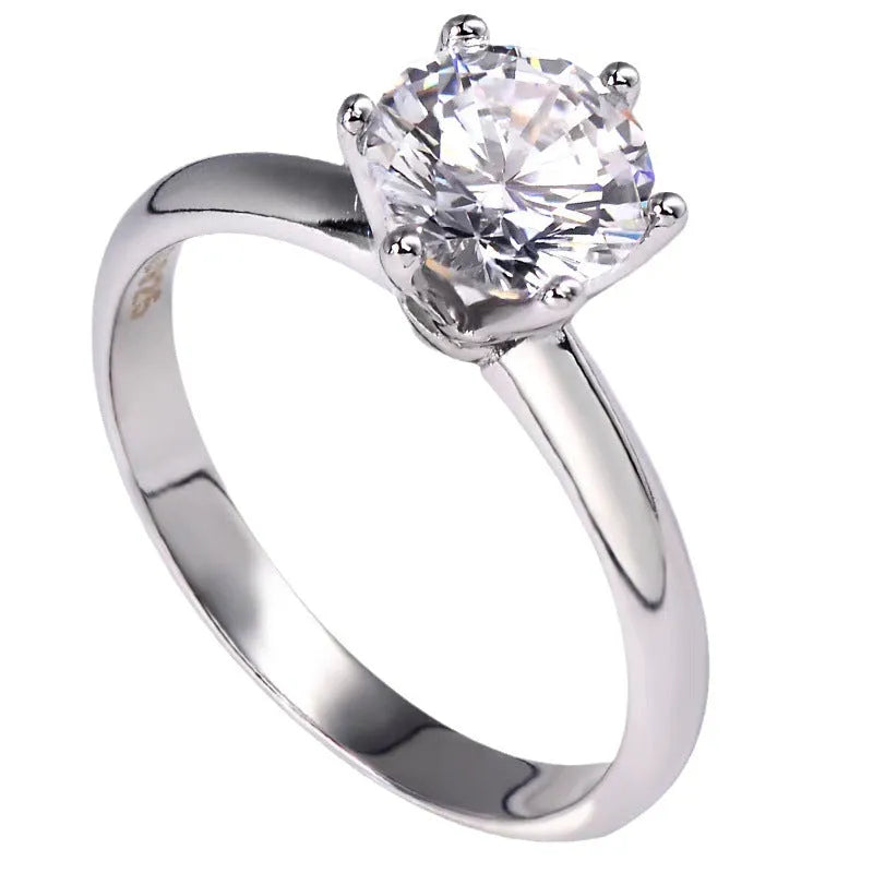 White gold plated ring with six-claw setting holding a central zircon stone on a geometric band.