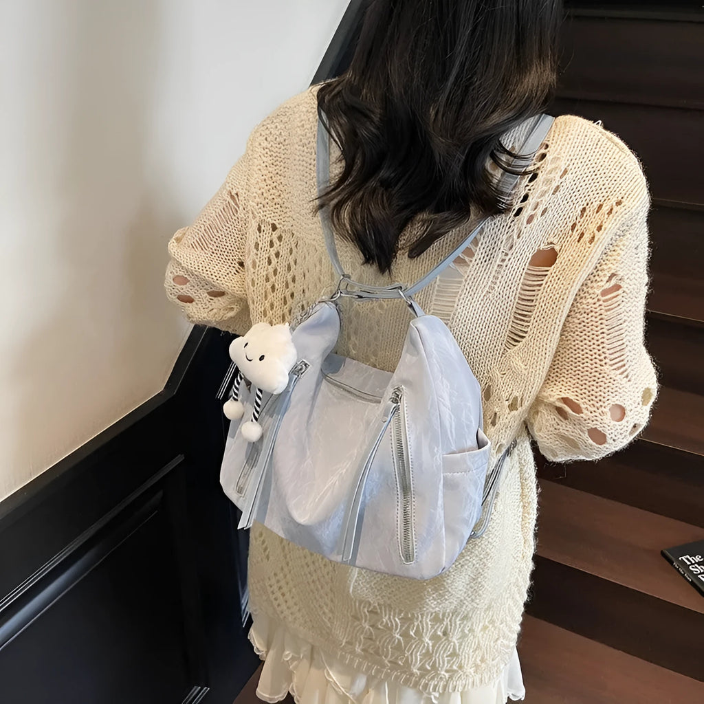 Women's PU leather fashion backpack in beige, black, blue, or silver with pendant accessory