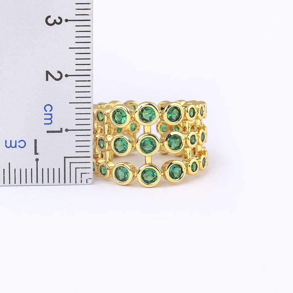 Copper ring with 18K gold plating, green zircon stones, and exaggerated three-layer wide band design.