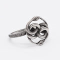 Close-up of a titanium steel double snake ring in a steel colour on a hand.