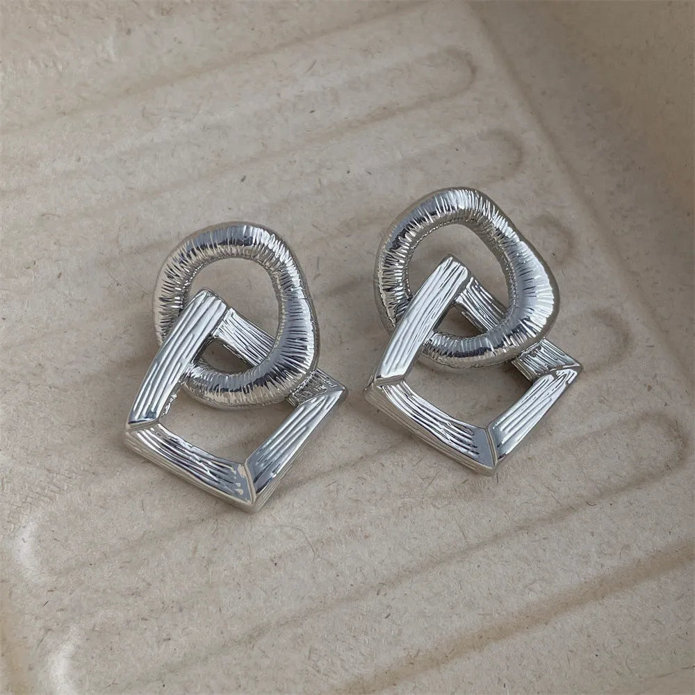 A pair of retro-style geometric circle drop earrings in a gold tone with a 3.4cm pendant length.