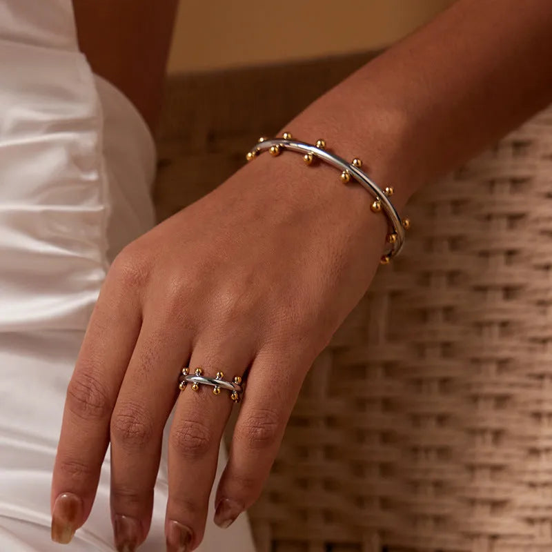 Stainless steel C-shaped bean beads with texture rivet detail in gold, steel, and steel gold colours.