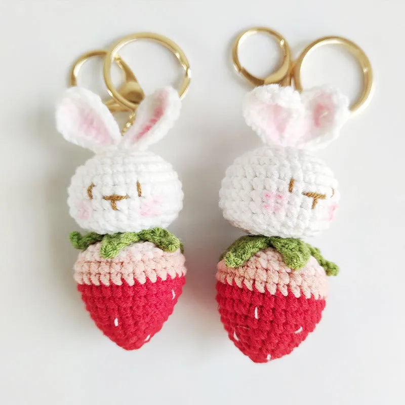 Hand-woven white rabbit strawberry pendant with keychain on grey background