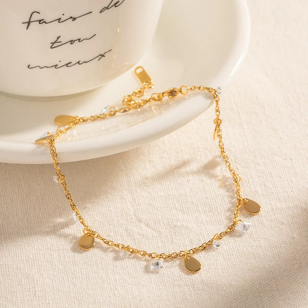 Women's stainless steel anklet with a silver water drop tassel charm and geometric links on an adjustable chain.