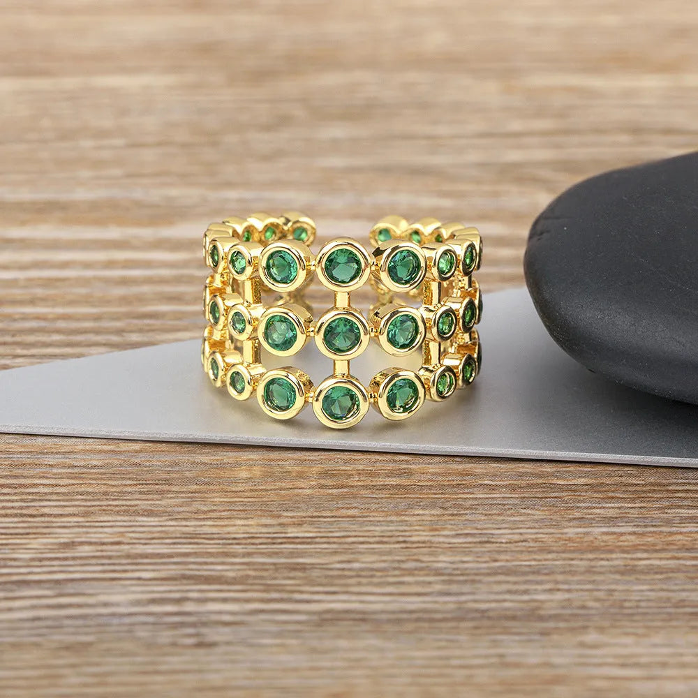 Copper ring with 18K gold plating, green zircon stones, and exaggerated three-layer wide band design.