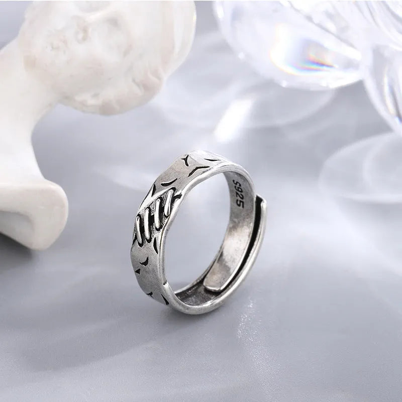 Black geometric copper ring with adjustable opening, showing round and oval design elements
