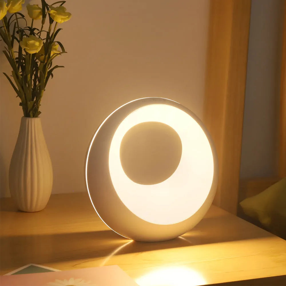 Small white RGB colour changing desk lamp with remote control on a table