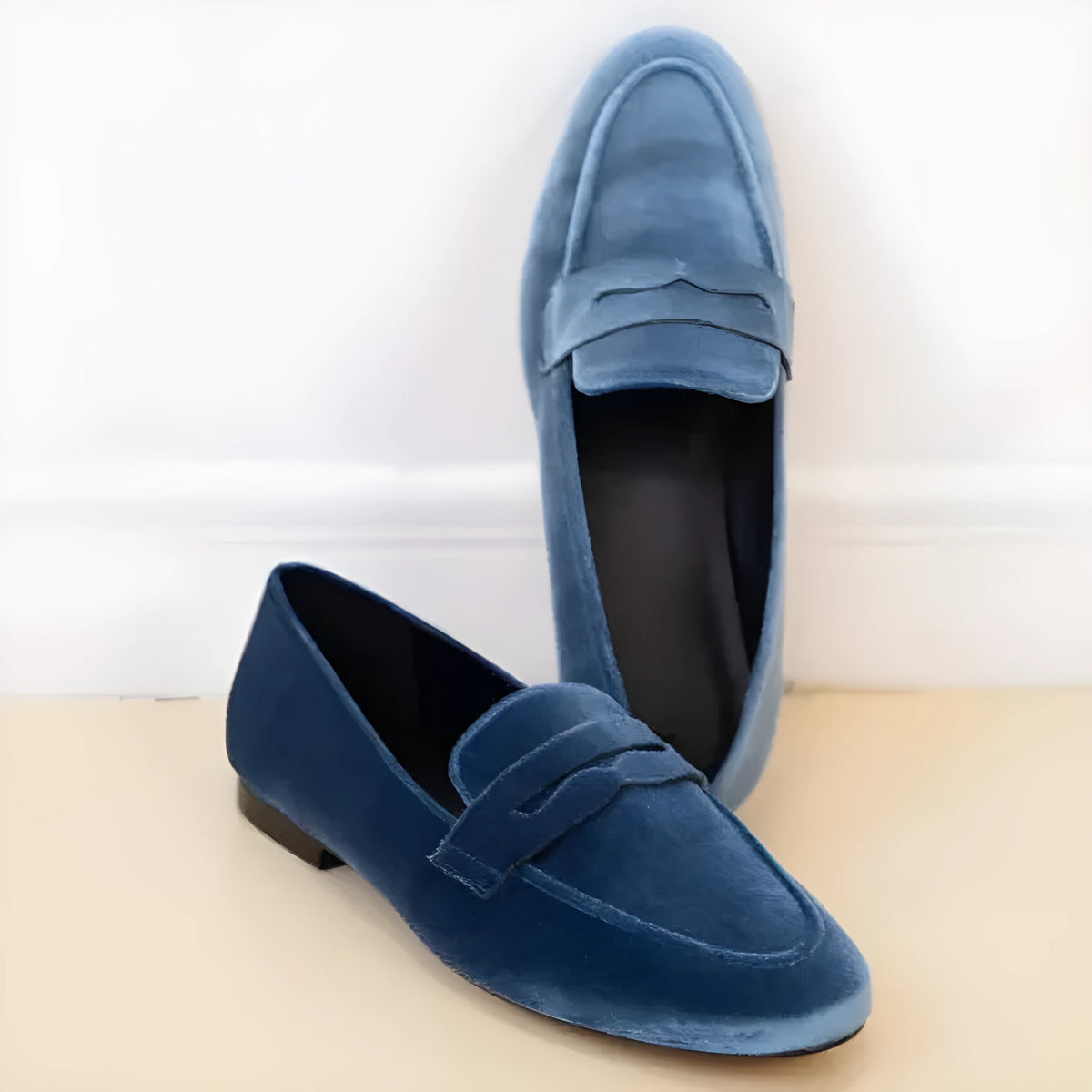 Blue women's flat loafers with a black rubber sole and suede-like PU upper on a white background.