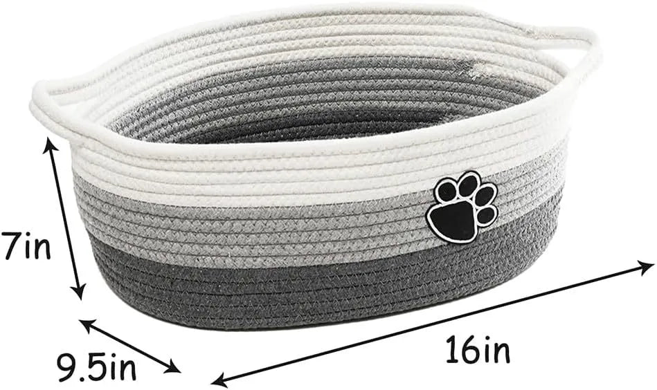 Small light beige handmade woven cotton rope storage basket with a handle on a wooden floor.