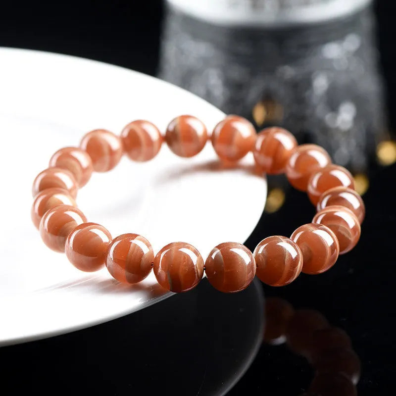 Natural pink old mine rhodochrosite round bead bracelet with a silver Ruyi charm.