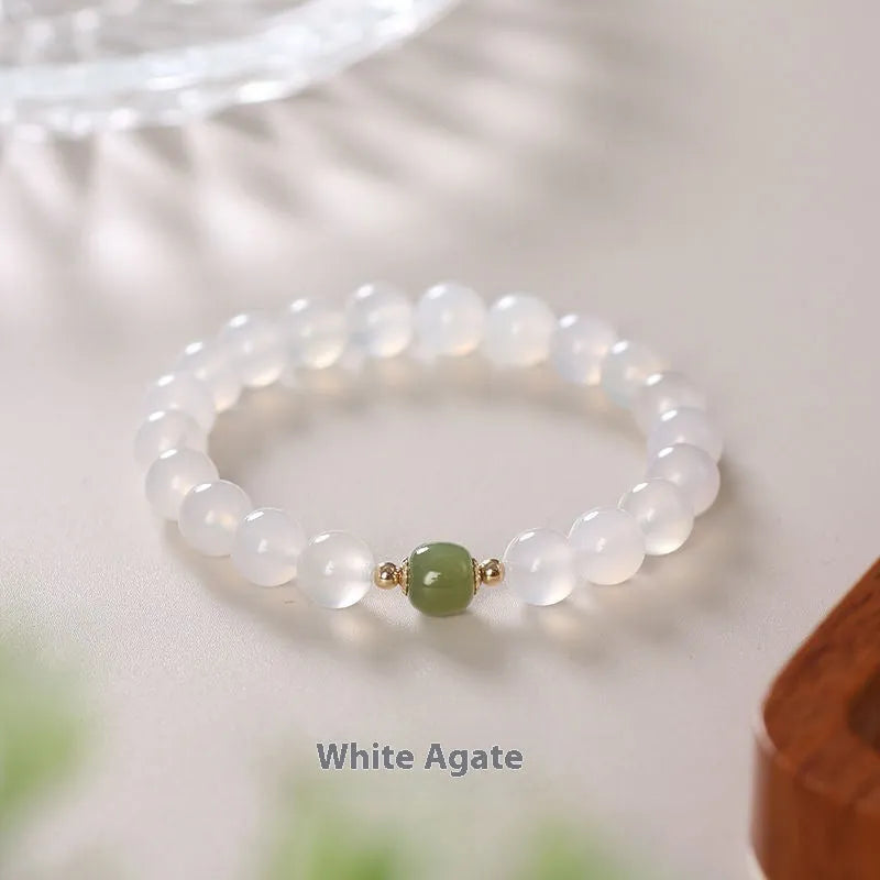 Handmade white agate and crystal bracelet with red cinnabar inlay and text charm.