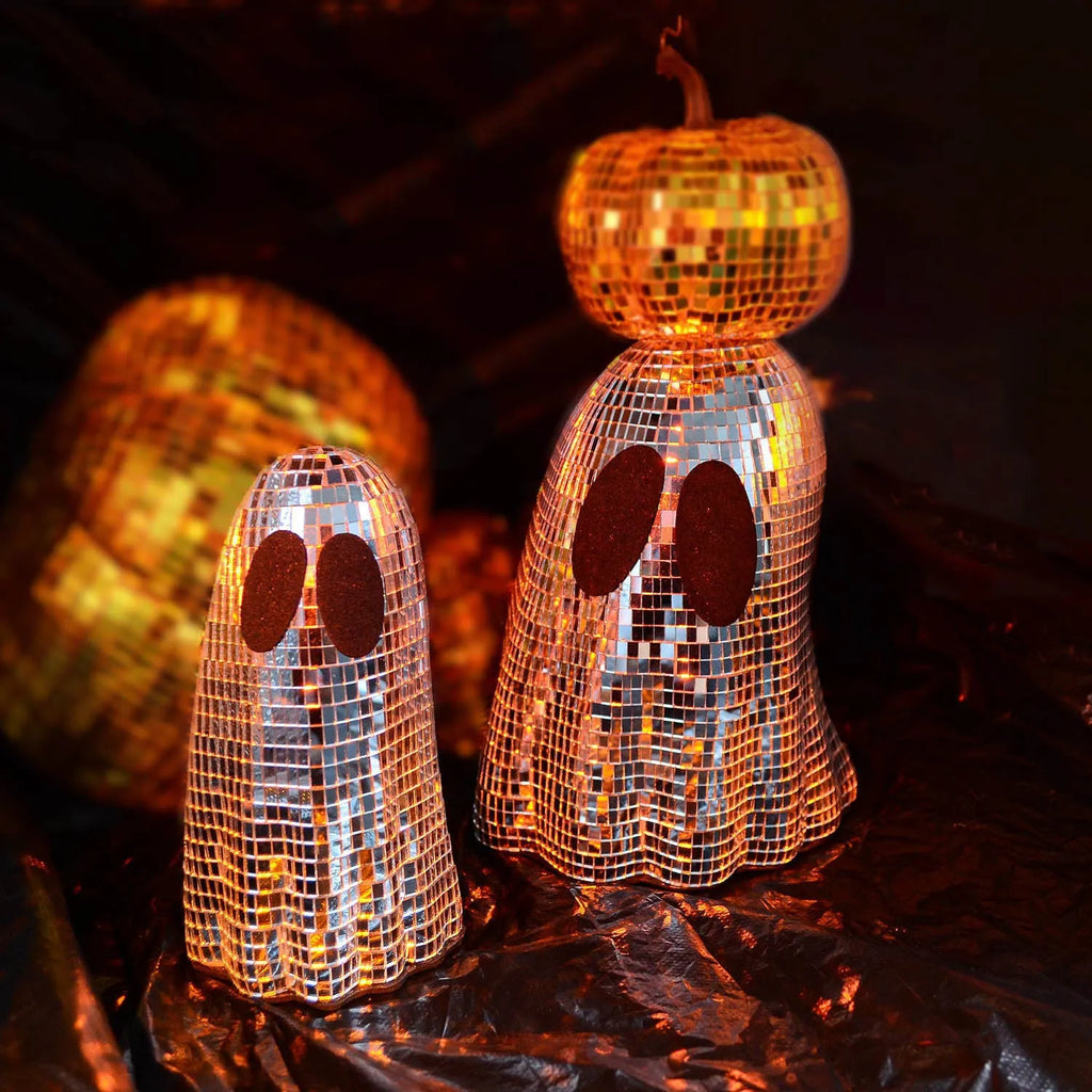 Silver glass Halloween ghost mosaic desktop decoration on a dark surface.