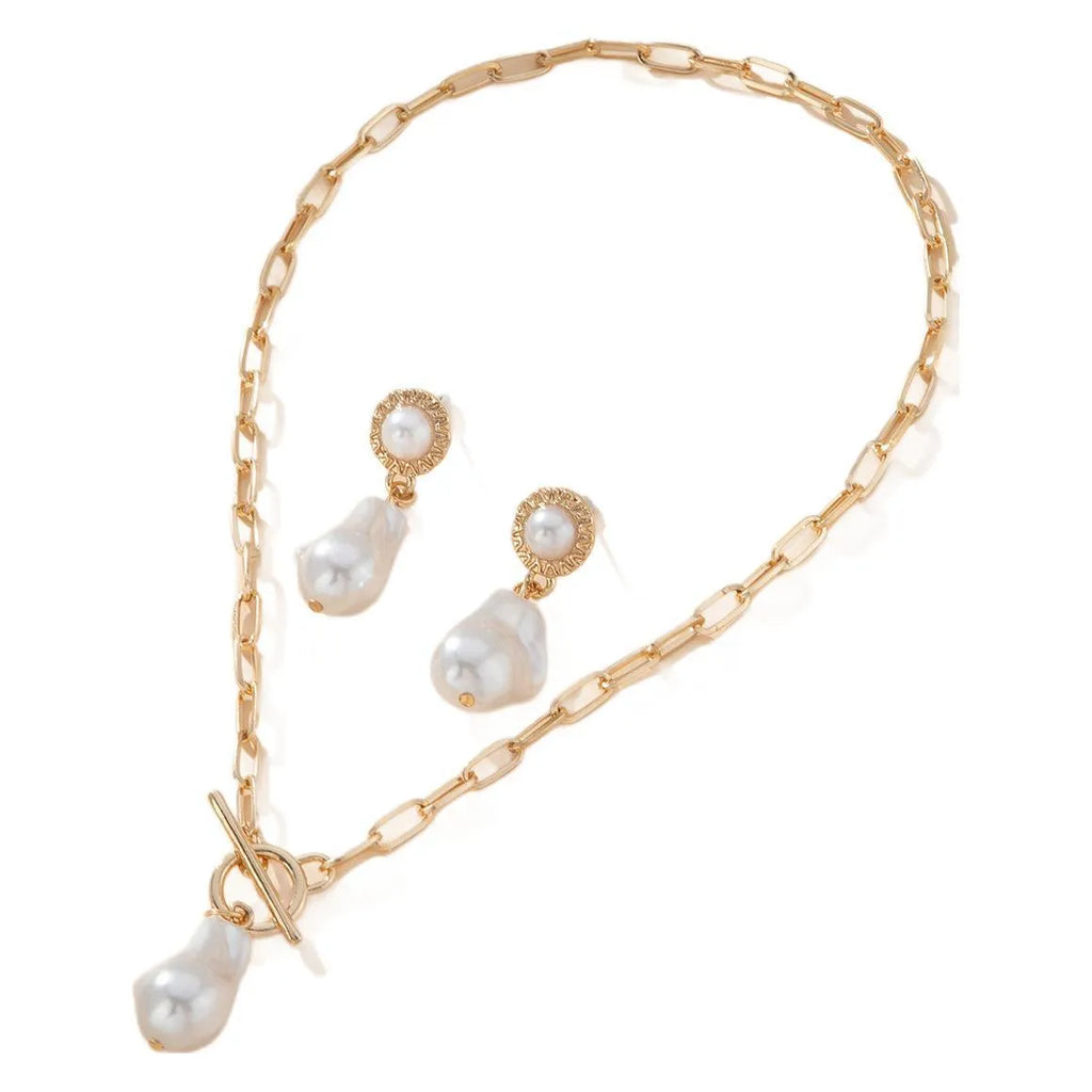 Gold-colour iron necklace and earring set with a baroque pearl pendant on a woman.