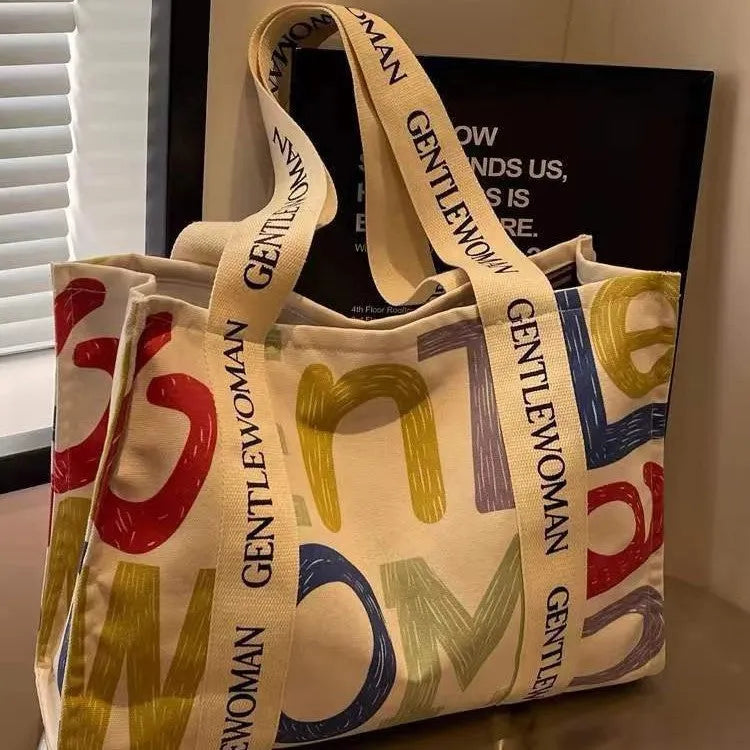 Women's large capacity canvas tote bag with printed design in three colour options.