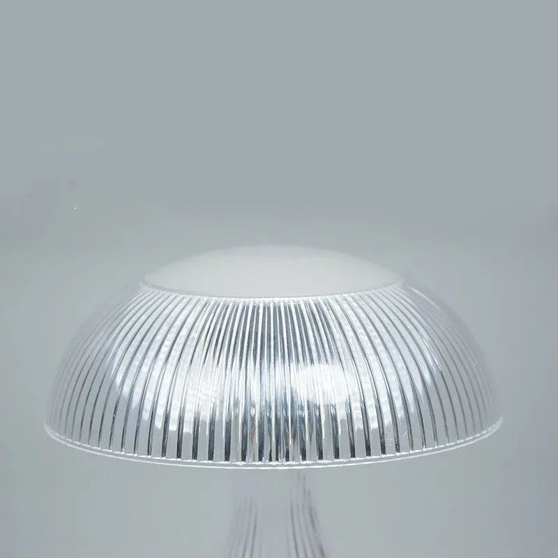 Small white rechargeable table lamp with acrylic body and USB cable, showing three colour light settings.