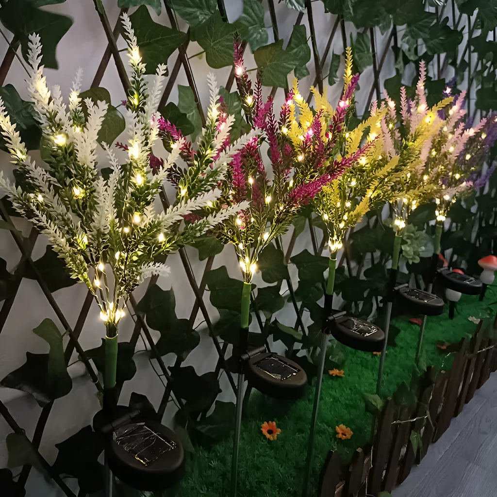74cm tall pink lavender-shaped solar garden light with green stem, placed in a garden bed.