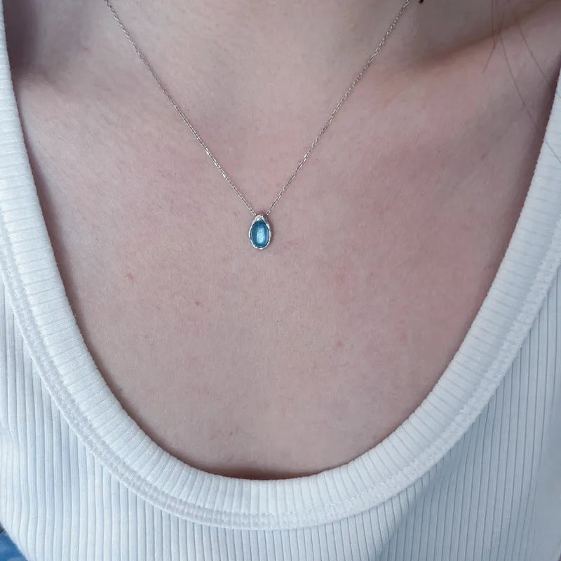 Women's navy blue water drop necklace with geometric pendant on adjustable cross chain