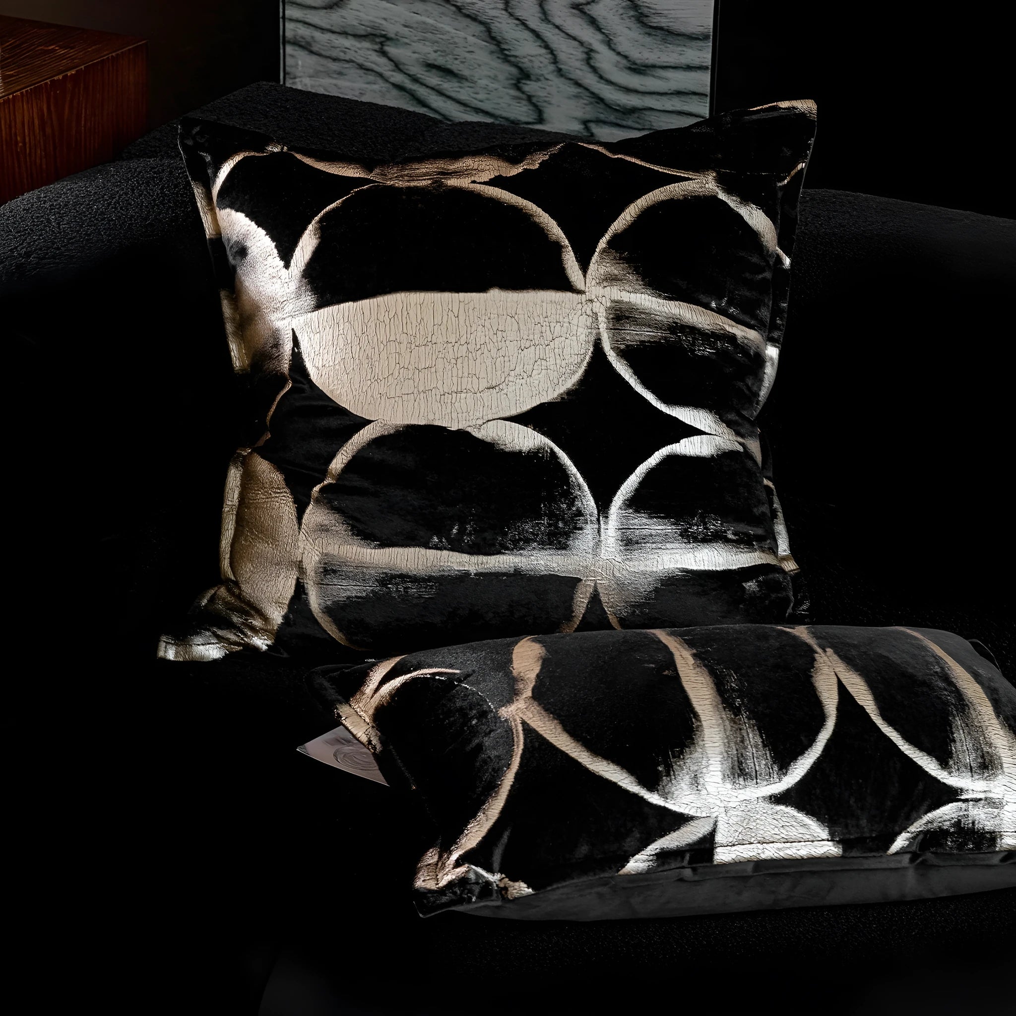 Black and gold abstract pattern cushion with flannel cover on a grey sofa