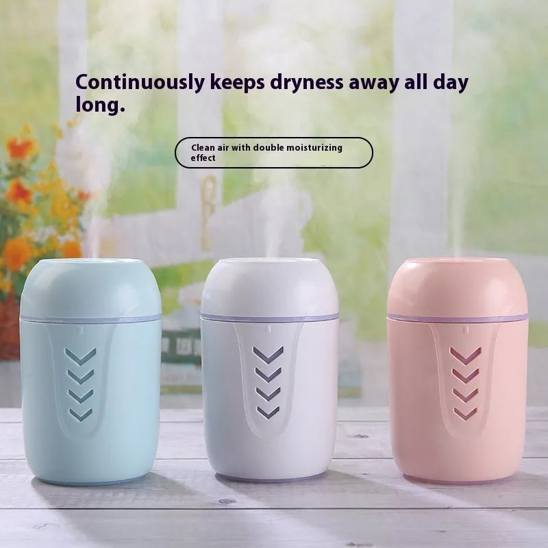 Round blue portable air purifier and aromatherapy diffuser unit with USB cable on a wooden desk.