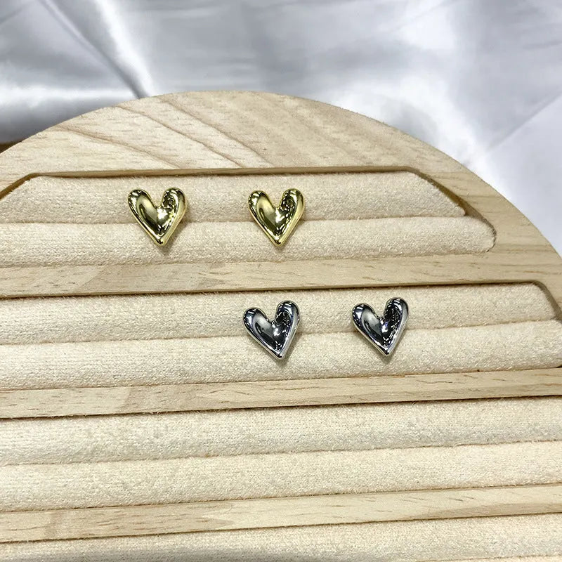 Heart-shaped stud earrings in gold and silvery metal alloy for pierced ears, simple small design