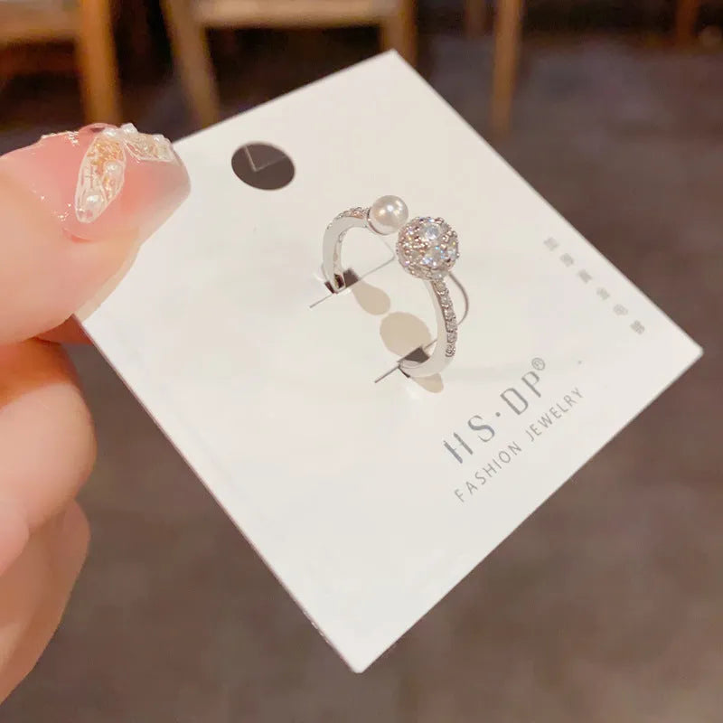 Open-end pearl ring with round zircon stones in geometric design with gold plating