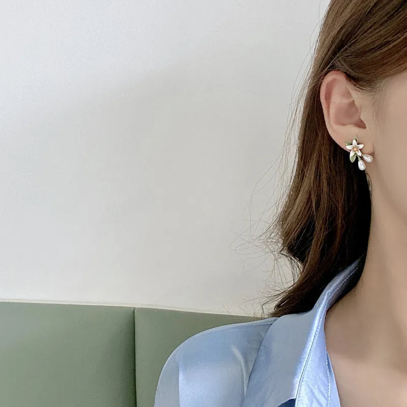 Women's alloy flower earrings with needle camellia design in sterling silver colour, shown as clip-on and ear stud styles