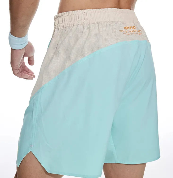 Man's loose grey workout shorts with elastic waist and lace-up fly, side view.