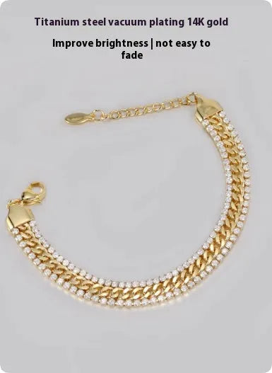Gold coloured hip hop style tennis bracelet with chain links and artificial gemstone inlays on a wrist.