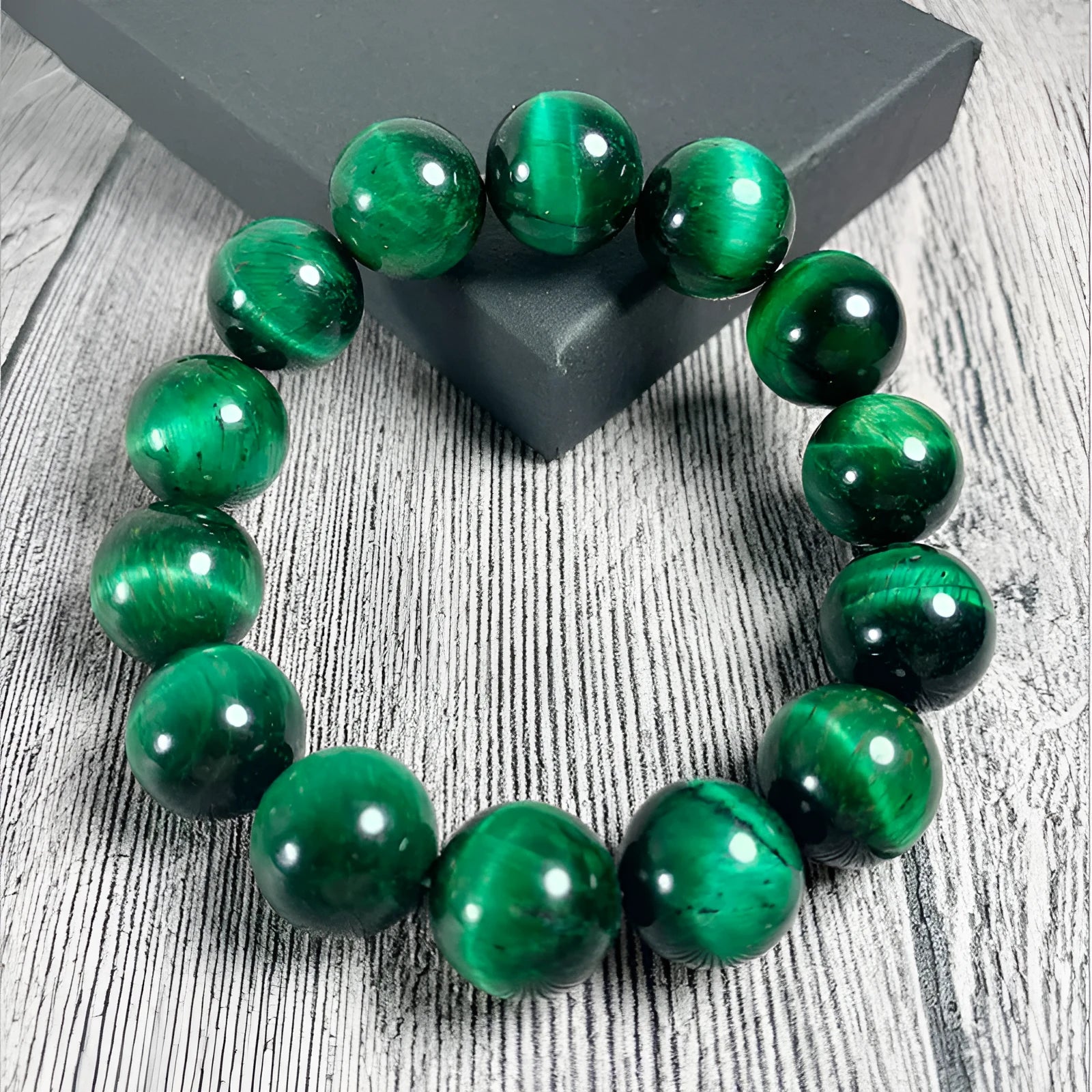 A green tiger eye stone beaded bracelet with geometric polished beads on an adjustable cord.
