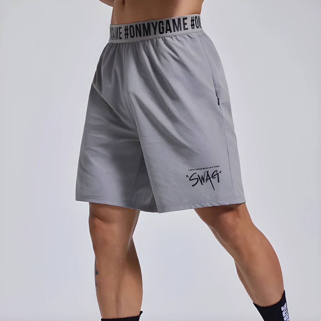 Men's loose sports shorts in black with elastic waist and printed letter details