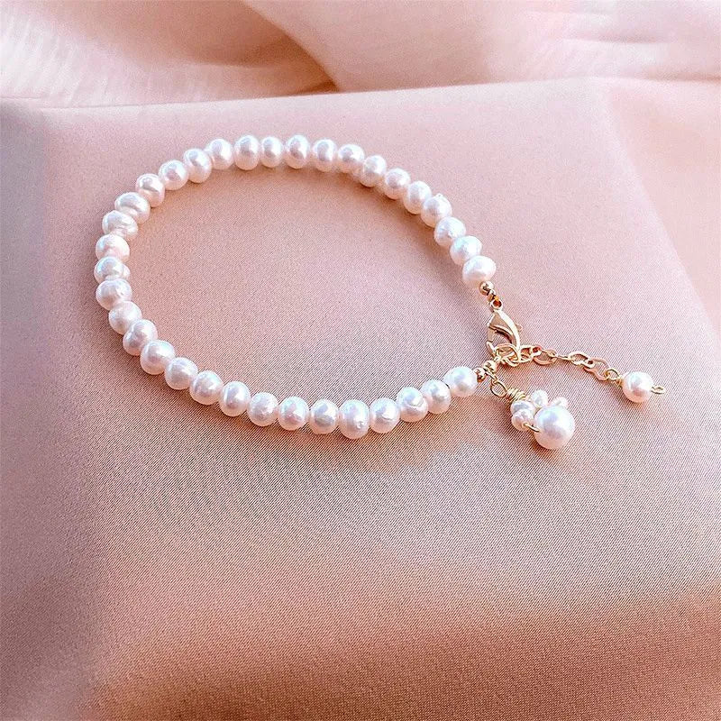 Women's white freshwater pearl cat's paw bracelet with electroplating finish on a neutral background