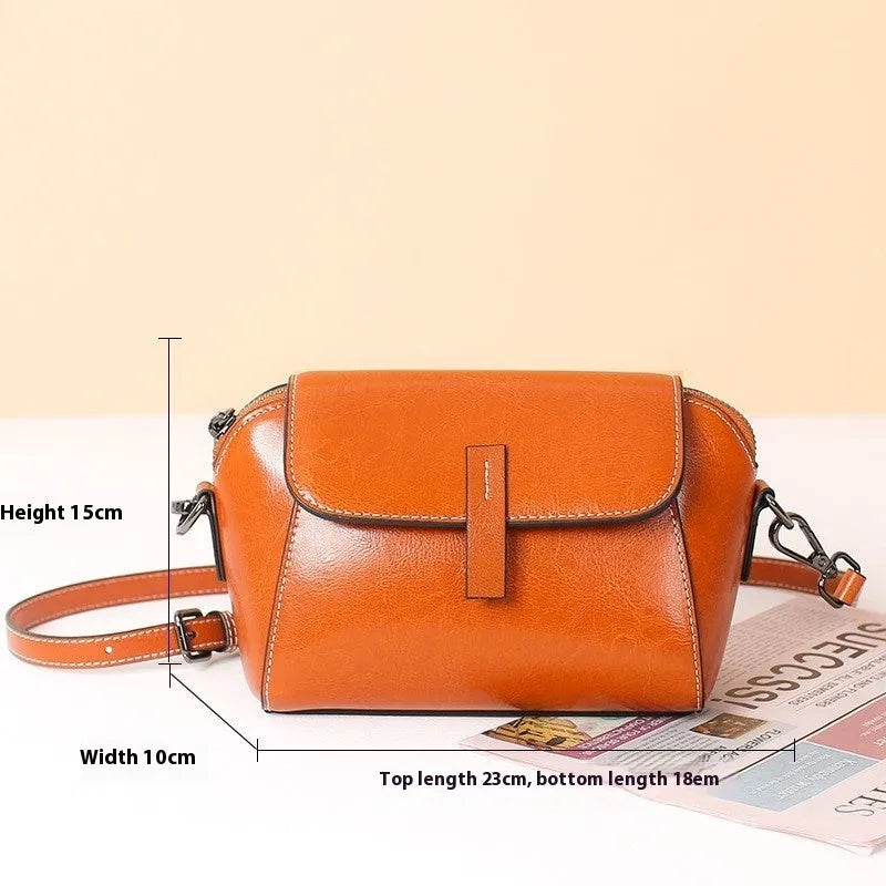 Women's brown cowhide leather shell messenger bag with cross-body strap and multiple internal compartments