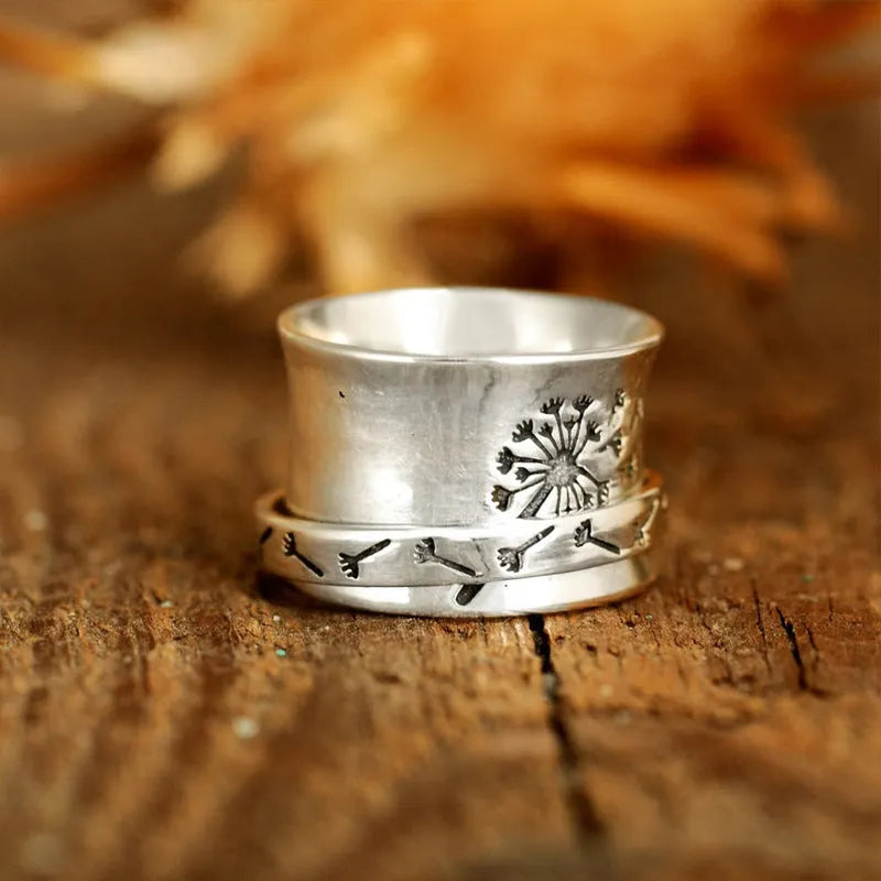 Silver rotatable flower ring showing petal detail and band, displayed with sizing options 7 through 11