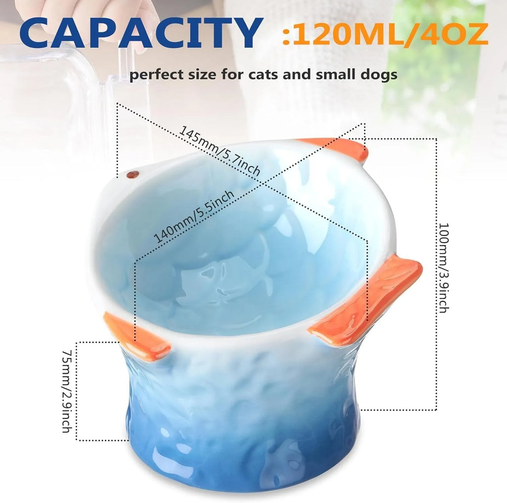 Blue ceramic cat food bowl in a fish shape with a tilted, elevated design and non-slip base.