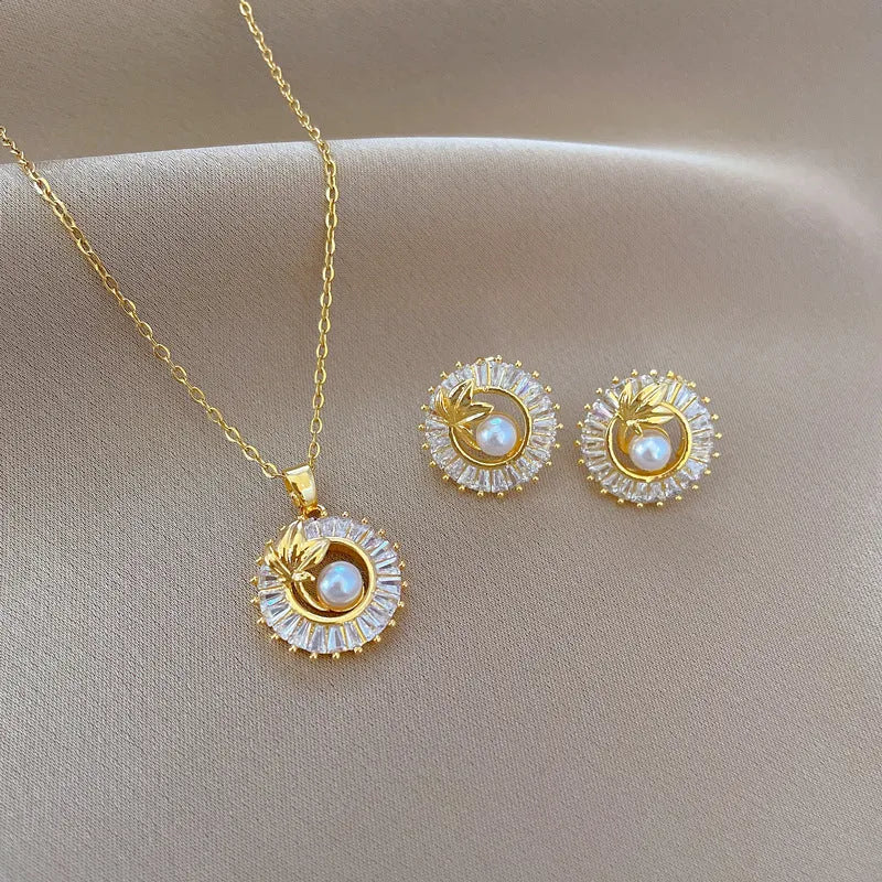 Women's geometric jewellery set with square diamond accents, ring and leaf motif on necklace and matching stud earrings.