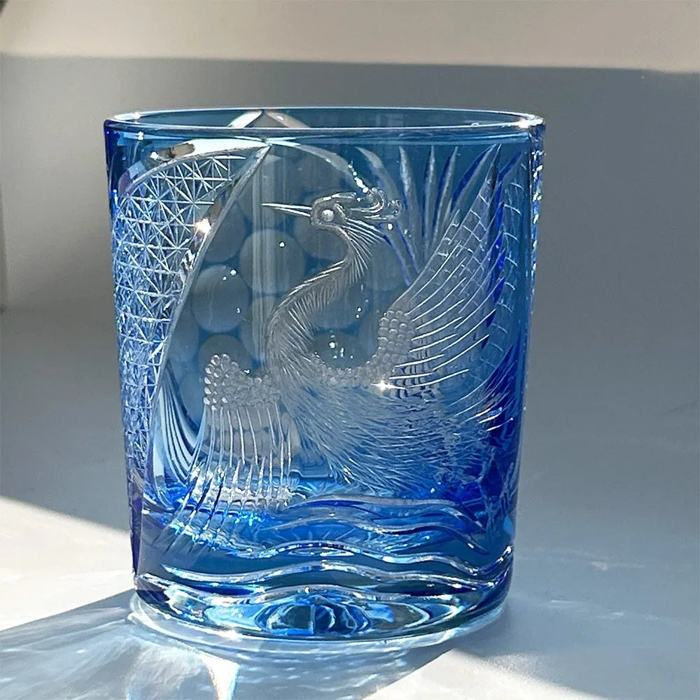 Hand-carved sky blue crystal whiskey shot glass on a wooden surface, 90x100mm size