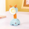 Small plastic cartoon animal night lamp with a magnetic adjustable base on a desk.