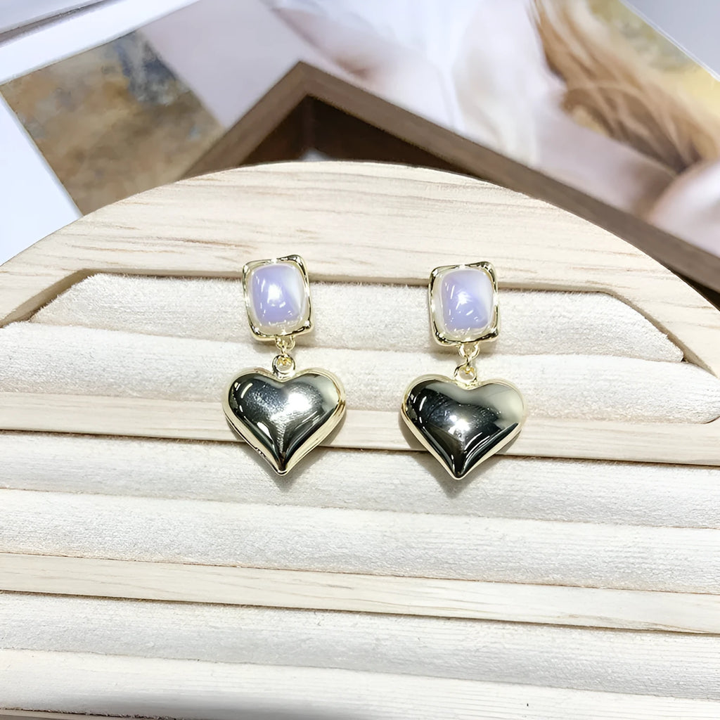 Small gold heart earrings with metal construction and post backing