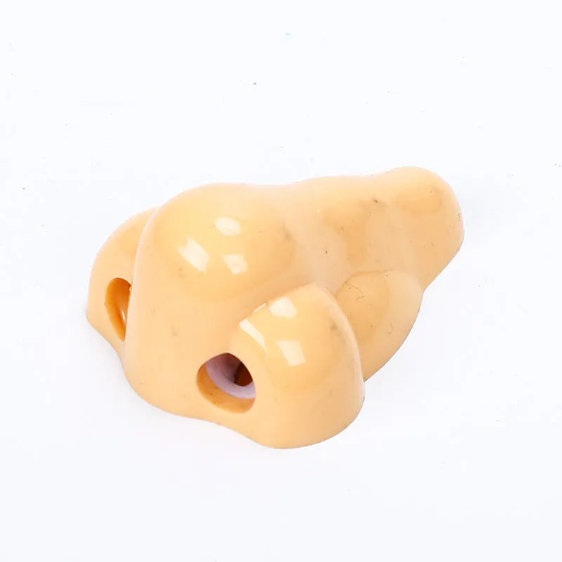Flesh-coloured plastic geometry-shaped pencil sharpener with a large nostril.