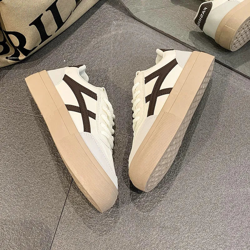 Blue and brown low-top lace-up board shoes with patent leather upper and flat rubber sole.
