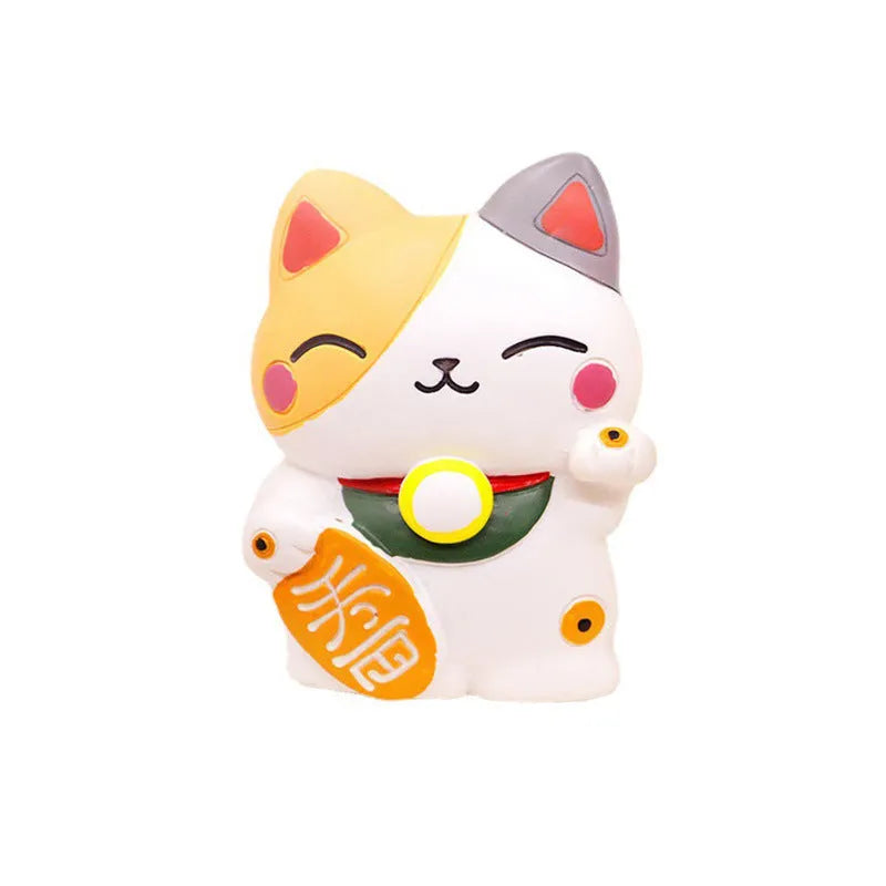 Black and white resin fortune cat ornament designed to clip onto a car air vent as an aromatherapy diffuser.