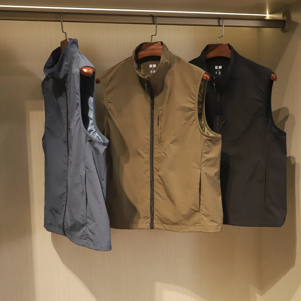 Men's straight-cut nylon vest in army green with side seam pockets, laid flat.