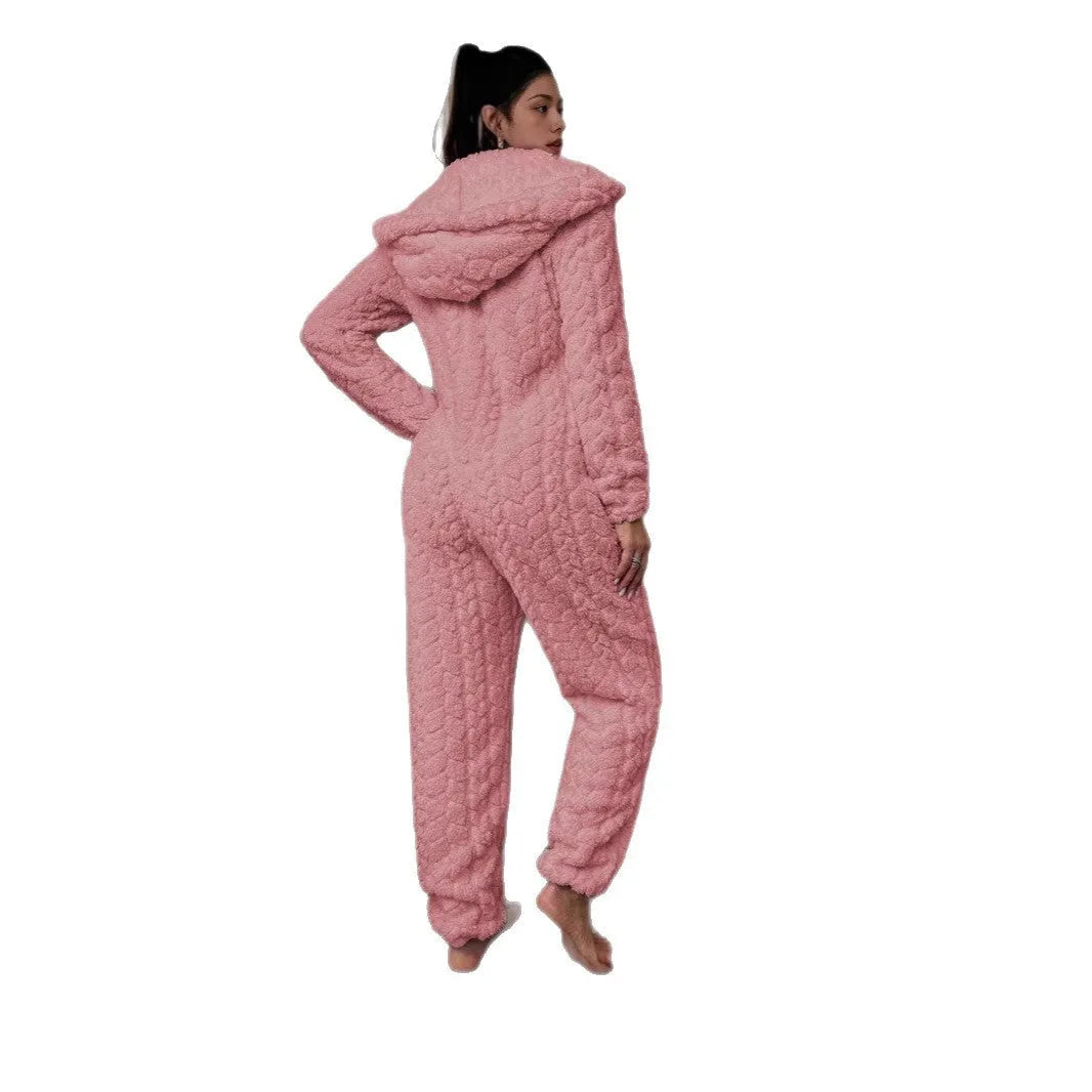 Beige hooded thickened coral fleece one-piece pajama with long sleeves on a woman standing indoors