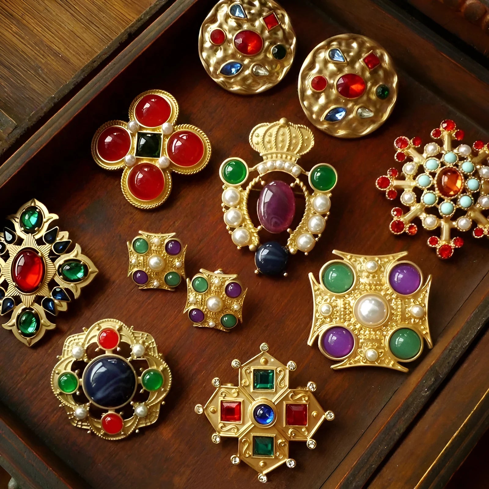 A selection of eight different zinc alloy retro baroque brooches in a diamond shape on a fabric background.