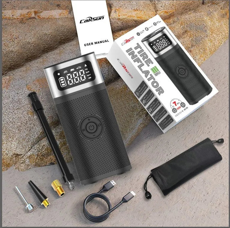Black portable wireless smart vehicle air pump with hoses and nozzles on a storage bag.