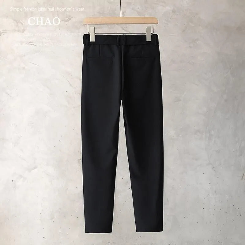 Boy wearing slim straight wool trousers in a neutral colour, showing tapered leg and straight hem.