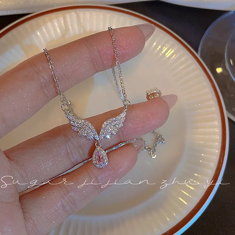 Women's sterling silver necklace with geometric angel wing or fishtail pendant on an O-ring chain.